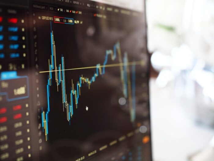 monitor ligado mostrando gráficos do mercado financeiro